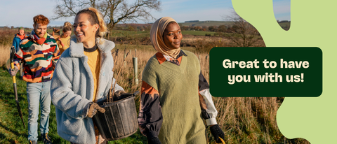 Group of diverse people planting trees in a field, with a message "Great to have you with us" overlaid.