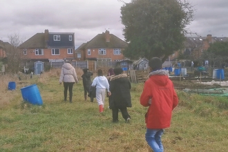 a group of young people walking through allotments