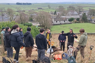 Group of people stood on a hillside ready to plant trees