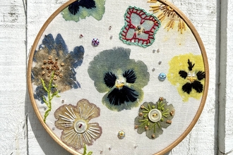 A completed embroidered ring with flowers decorated within it