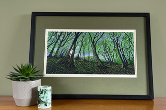 a photograph of a framed painting of sunlight through trees