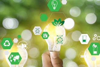 A person holding a lightbulb surrounded by icons for sustainability