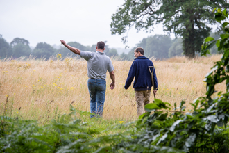  Farmer and advisor walking in a field talking