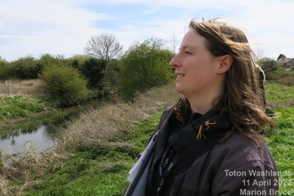 a woman stood next to a canal looking to the left