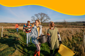 people walking through a field with buckets