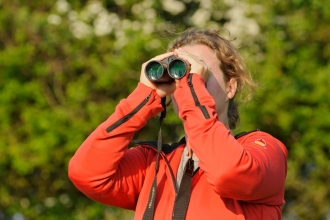 Young woman birdwatching at Rutland Water