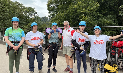 6 people stand in a row on millers dale bridge ready to abseil down it