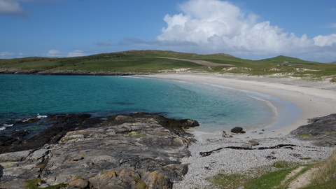 a landscape picture of the outer hebrides with the sea and blue sky with few clouds