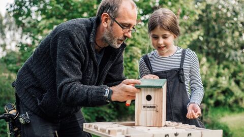 Image of a man helping a girl to make her own bird box