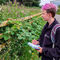 a woman with pink hair and a derbyshire wildlife trust fleece conducting a pollinator survey 