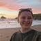 Frankie Selby on a beach with the sunset in the background