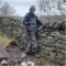 Rohan Byrt next to a drystone wall smiling