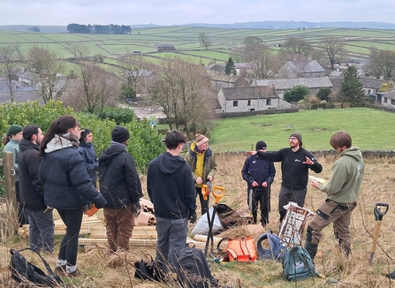 Group of people stood on a hillside ready to plant trees