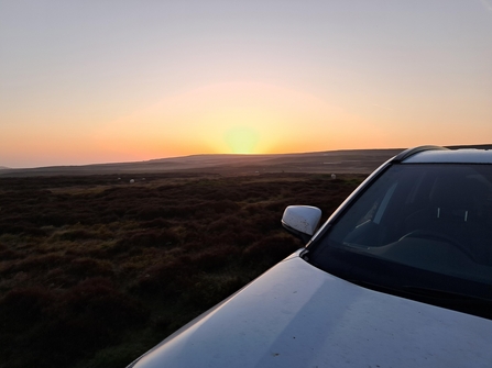 car on a welsh moor at sunrise