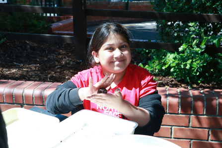 a child smiling and making a seed bomb