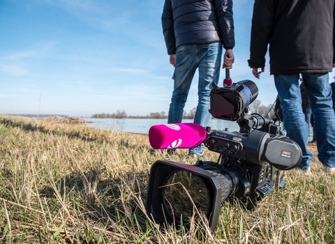 the back of two people with a video camera in the forefront