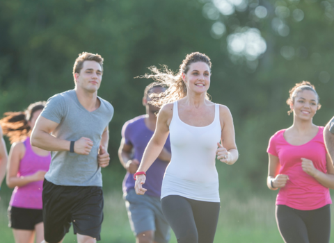 a group of people running through a park