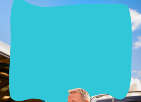 a man smiling sat on the back of a truck